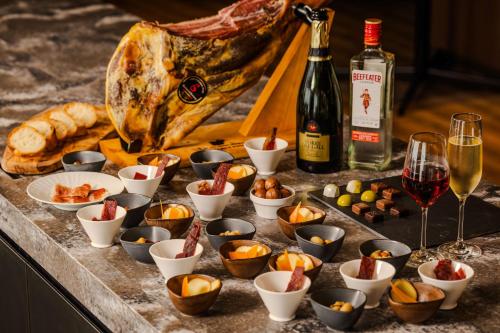 a table with cups of food and a bottle of wine at Stadium City Hotel Nagasaki in Nagasaki