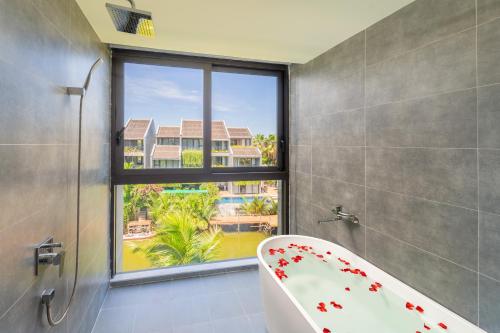 a bathroom with a bath tub and a window at Coco villa in Hoi An