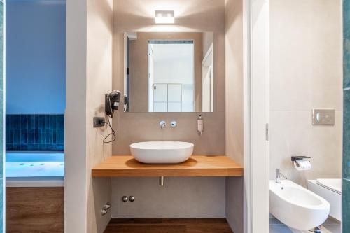 a bathroom with a sink and a mirror at Palazzo Italia Suites in Bari