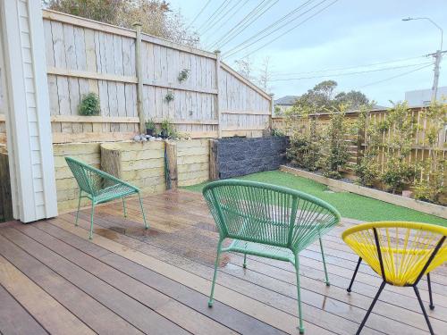 two green chairs sitting on a wooden deck at Stylish Family Retreat in Hillcrest 4 Bedroom and Playroom in Auckland