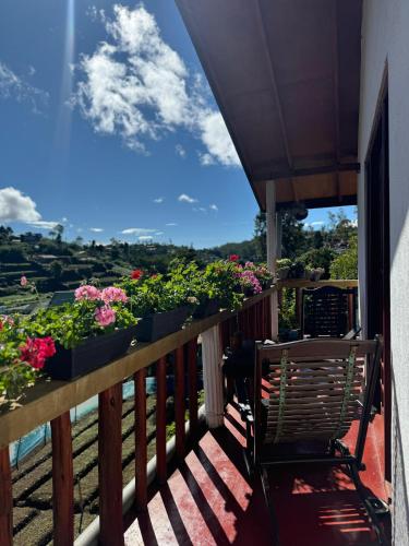 a balcony with potted plants and a table and chairs at Cozy Heaven in Nuwara Eliya