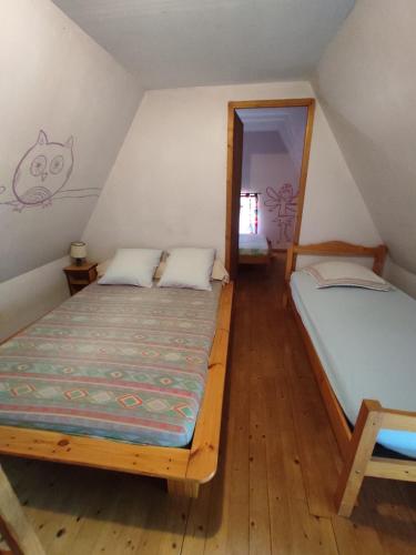 une chambre avec deux lits dans un grenier dans l'établissement maison rénovée traditionnelle en chaume, à Kervignac