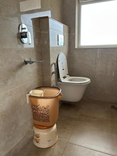 a bathroom with a toilet and a window at Swami Prasad Paradise hotel in Golitattu