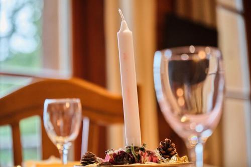 a candle on a table with two wine glasses at Chalet il fera beau demain in Villard-Reculas