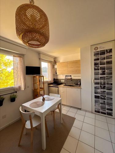 une cuisine avec une table blanche et des chaises dans l'établissement Évasion bord de mer Studio à 50m de la plage, à Saint-Brévin-les-Pins