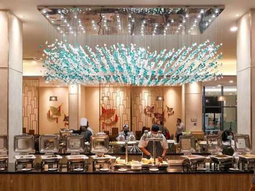 a restaurant with people standing behind a counter at Comfy Imperium Residence Kuantan Studio Seaview in Kuantan