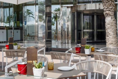 a patio with tables and chairs in front of a building at Hotel Palma Bellver , Affiliated by Meliá in Palma de Mallorca