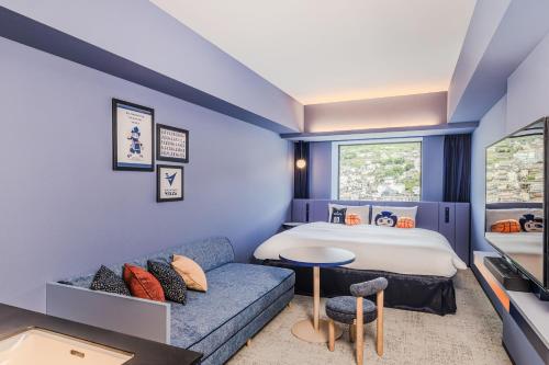 a hotel room with a bed and a couch at Stadium City Hotel Nagasaki in Nagasaki