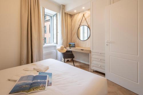 a bedroom with a bed with two books and a desk at Novos Central Apartments in Lugano
