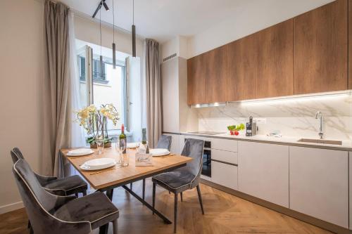 a kitchen with a wooden table and chairs in a room at Novos Central Apartments in Lugano