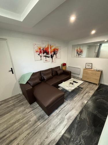 un salon avec un canapé marron et une table dans l'établissement Proximité RER A , souplex tout confort, 2 chambres, à Saint-Maur-des-Fossés