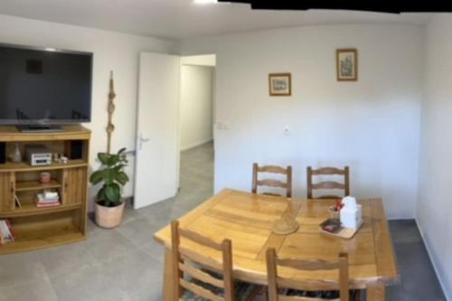 une salle à manger avec une table en bois et une télévision dans l'établissement Appartement de 38m2, à Gournay-sur-Marne