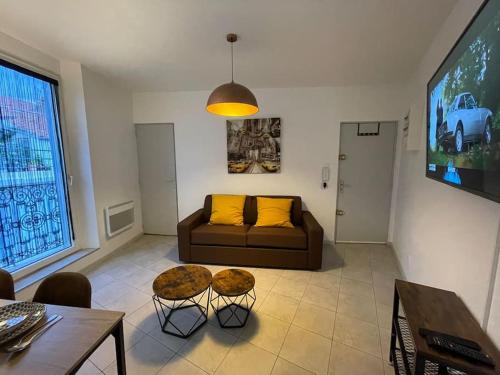 a living room with a couch and a tv at Bel appartement Béziers - Clim - 1 Chambre - Gare - Centre in Béziers