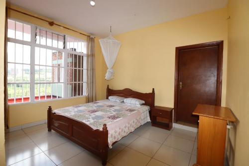 a bedroom with a bed and a window at MOUCECORE in Kigali