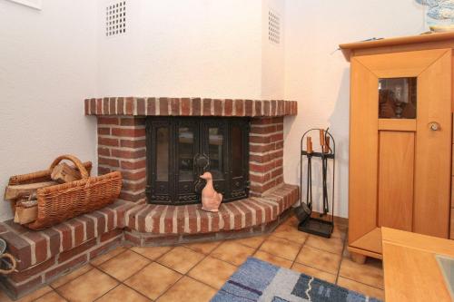 a brick fireplace with a vase in a room at Deichbrise in Greetsiel