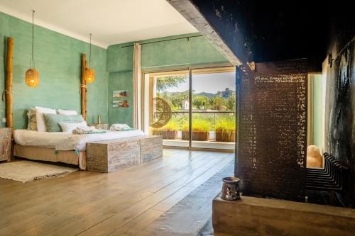 une chambre avec un lit et une grande fenêtre dans l'établissement LA VILLA, à Saint-Rémy-de-Provence