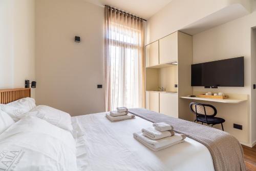 a bedroom with a white bed with towels on it at Palazzo Italia Suites in Bari
