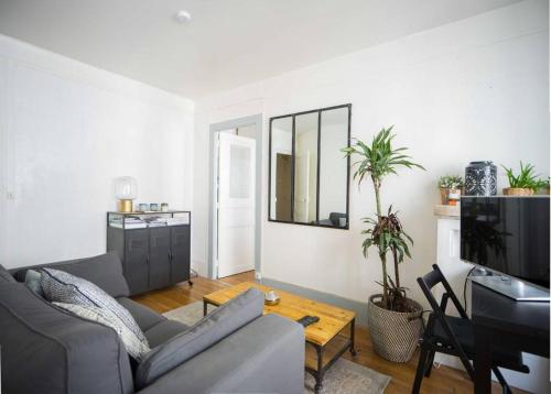 un salon avec un canapé et une télévision dans l'établissement L'appart Zen et Cosy du 15eme, à Paris