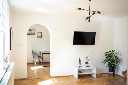 a living room with a table and a tv on a wall at Apartmány na Dolní in Rumburk