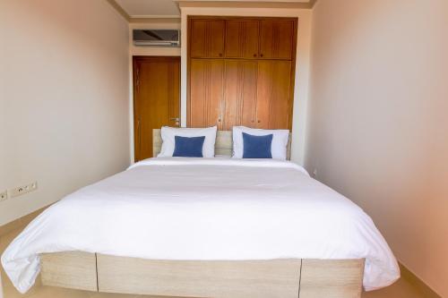 a bedroom with a large white bed with blue pillows at Paradis Bleu - Piscine - Luxe - 4 Px in Imi Ouaddar