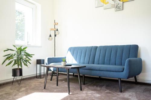 a blue couch in a living room with a table at Apartmány na Dolní in Rumburk