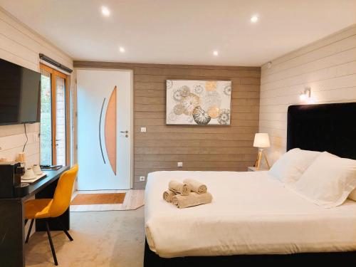 a bedroom with a bed with a pair of shoes on it at Domaine de la Haie des Granges in Ménilles