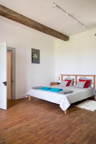 une chambre avec un lit dans une pièce blanche dans l'établissement Charming La Maison Des Artistes near Bergerac, à Conne-de-Labarde