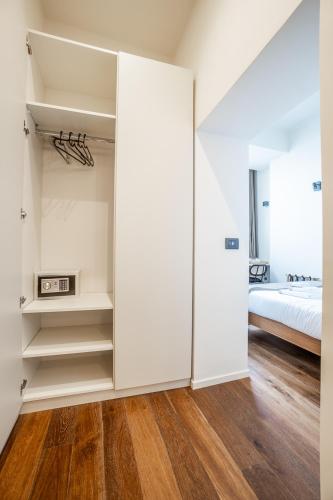 a bedroom with white walls and a bed and a closet at Palazzo Italia Suites in Bari