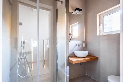 a bathroom with a glass shower and a sink at Palazzo Italia Suites in Bari