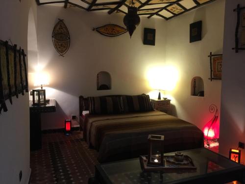 a bedroom with a bed and two lamps and a table at Riad Bab Essaouira in Essaouira
