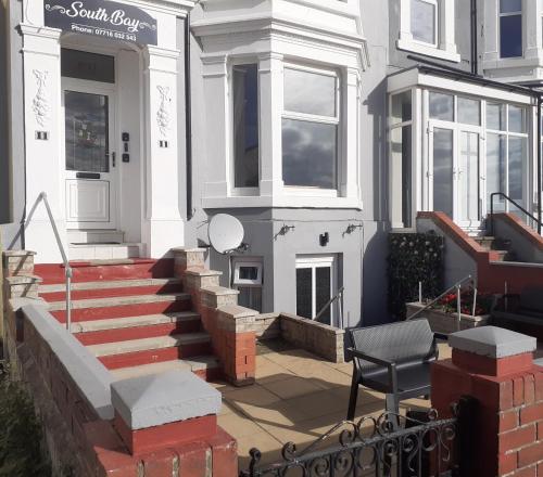 a white house with stairs leading to the front door at Southbay Room 2 in Bridlington