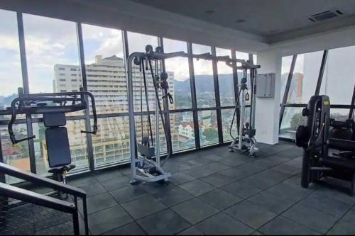 a gym with two tread machines in a room with windows at High Floor, 3BR 3queen bed, 2 parking, Urban Suites by XWHome in Jelutong
