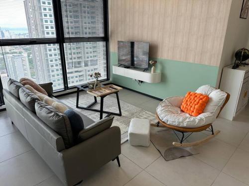 a living room with a couch and a chair at High Floor, 3BR 3queen bed, 2 parking, Urban Suites by XWHome in Jelutong