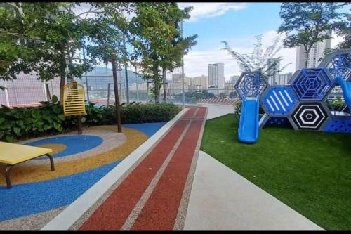 a park with two blue chairs and a bench at High Floor, 3BR 3queen bed, 2 parking, Urban Suites by XWHome in Jelutong