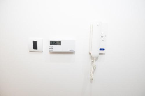 a phone hanging on a wall with a cord at DUGA PARK lux in Kragujevac