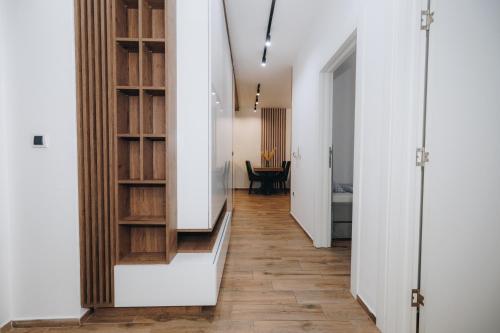 a hallway with white walls and wooden shelves at DUGA PARK lux in Kragujevac