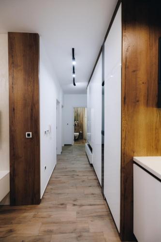 a hallway with white walls and a wooden door at DUGA PARK lux in Kragujevac