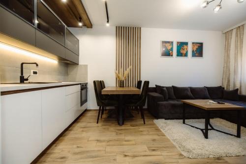 a kitchen and living room with a couch and a table at DUGA PARK lux in Kragujevac