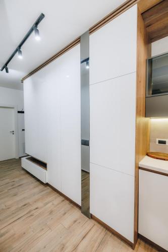 a room with sliding doors in a kitchen with wood floors at DUGA PARK lux in Kragujevac