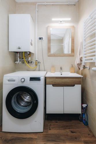 a bathroom with a washing machine and a sink at DUGA PARK lux in Kragujevac