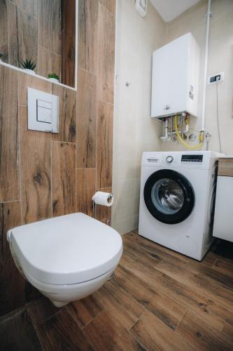a bathroom with a toilet and a washing machine at DUGA PARK lux in Kragujevac