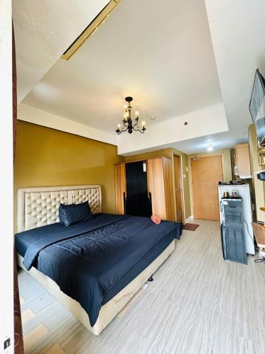 a bedroom with a large bed with a blue comforter at Kamar Apartemen Harian by Younz Apartmen Depok in Pondokcina