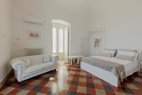 a white bedroom with a bed and a couch at Antica Dimora sul Mare - Luxury Central Apartments - Molfetta in Molfetta