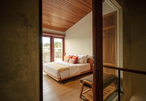 a bedroom with a bed and a window at Two Thirds Villa Canggu in Canggu