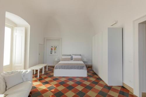 a white bedroom with a bed and a couch at Antica Dimora sul Mare - Luxury Central Apartments - Molfetta in Molfetta