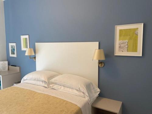 a bedroom with a large bed with a blue wall at Albergo Belsoggiorno in Sanremo