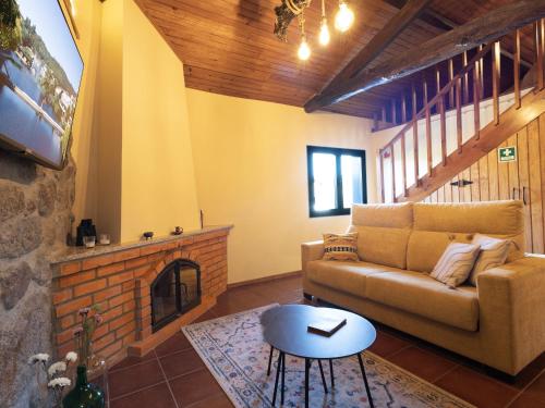 a living room with a couch and a fireplace at Quintinha do Varoso - Little Red Cottage House in São Pedro do Sul