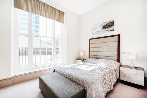 a bedroom with a bed and a large window at Luxury Marylebone Apartment M1 in London