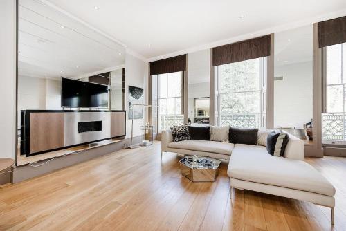 a living room with a couch and a flat screen tv at Luxury Marylebone Apartment M1 in London