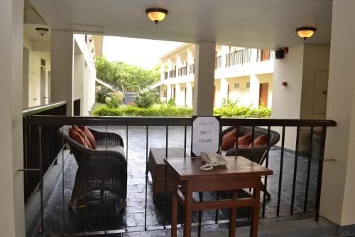 a balcony with two chairs and a table on a railing at Bagan Thiripyitsaya Sanctuary Resort in Bagan